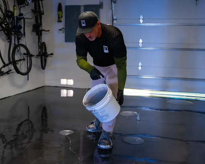 Installer pouring epoxy resin onto a garage floor