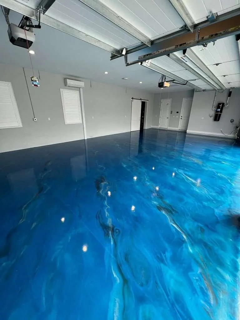 Ocean-blue metallic epoxy garage floor with swirling white and turquoise movement